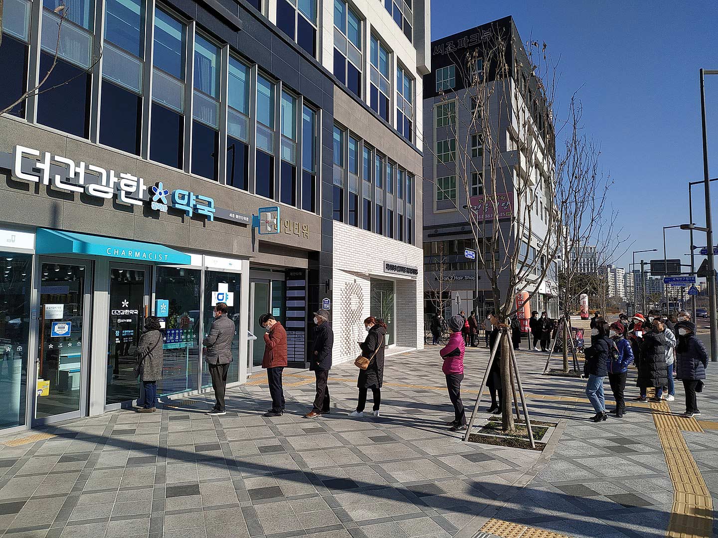 A long line outside a pharmacy in Sejong City awaiting the store to open so they can buy masks. Wikipedia Commons